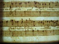 Santo orante inginocchiato recante una croce inscritto in uno scudo a tre punte (parte inferiore)